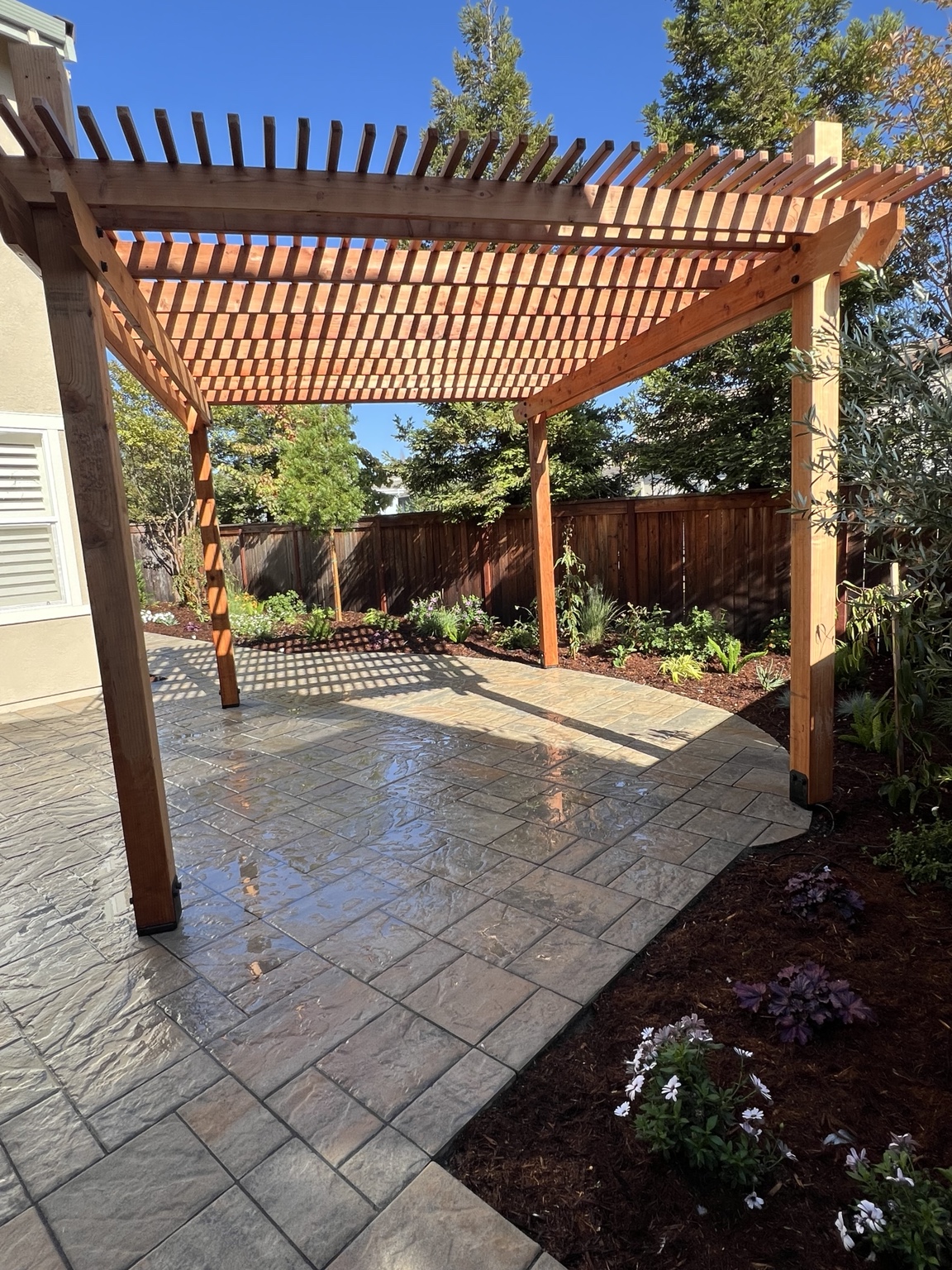 RJ Landscape paver patio beneath a wood pergola